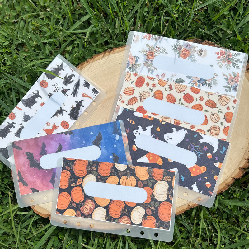 Collection of cash envelopes with various designs on a wooden block outdoors.