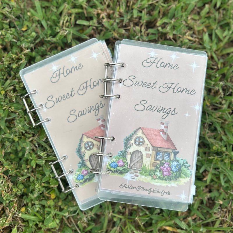 Two 'Home Sweet Home Savings' binders on grass