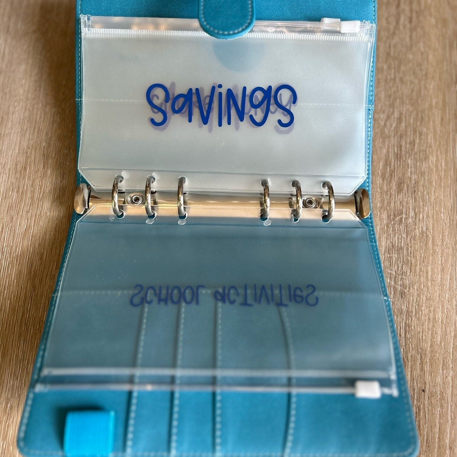 Personalized and custom kids money savings binder featuring a fun, tailored cover design, labeled cash envelopes, and budgeting tools, perfect for teaching children about money management and saving.