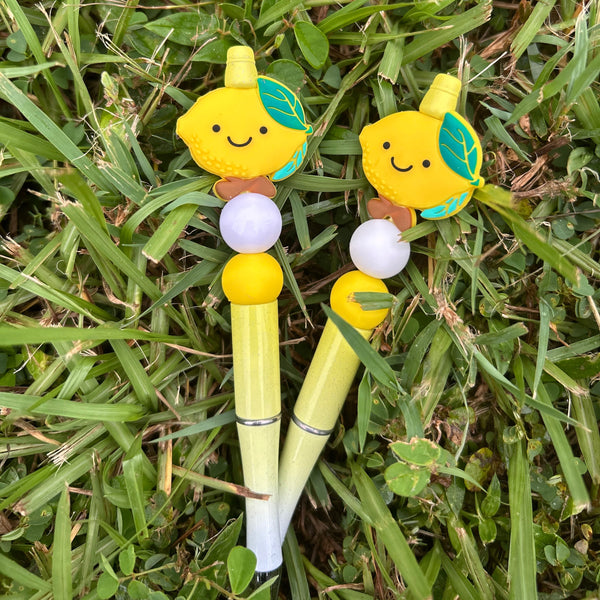 Two cartoon-style yellow pencils with faces on a grass background