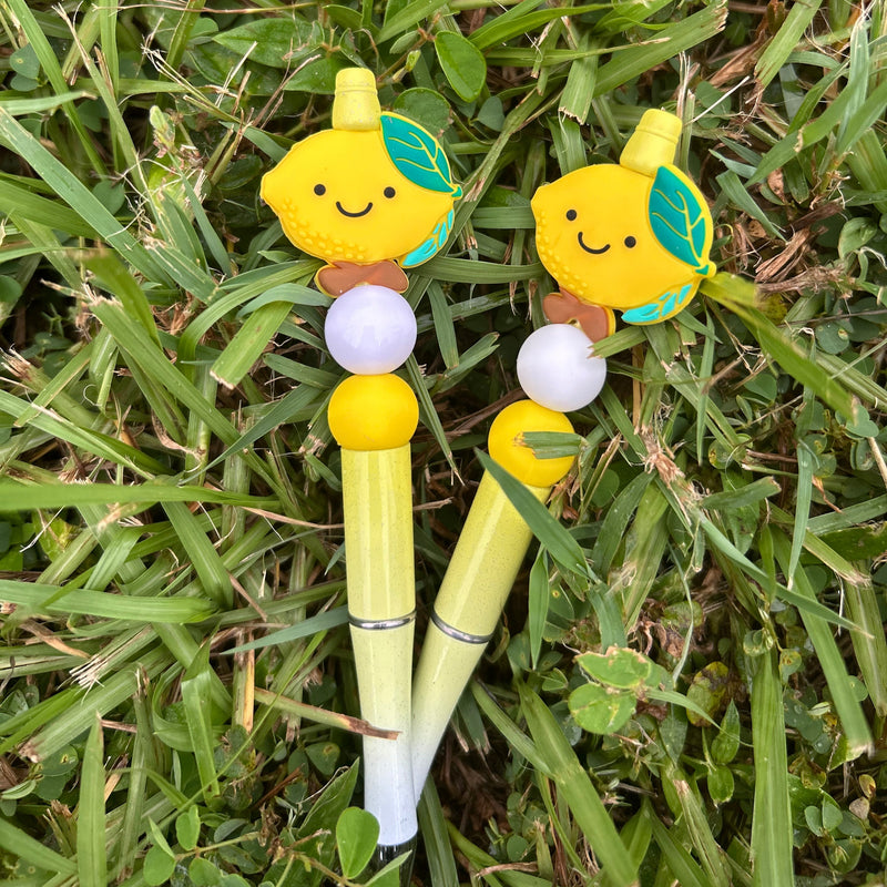 Two cartoon-style yellow pencils with faces on a grass background