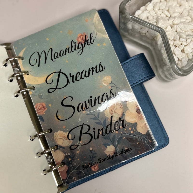Decorative notebook with 'Moonlight Dreams Savings Binder' text on a light background