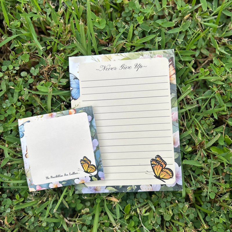 Notepad with butterfly design on grass