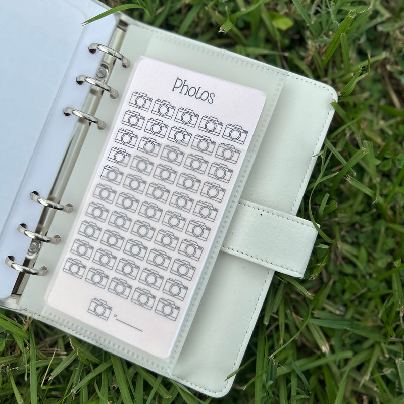 White planner with photo tracker on grass
