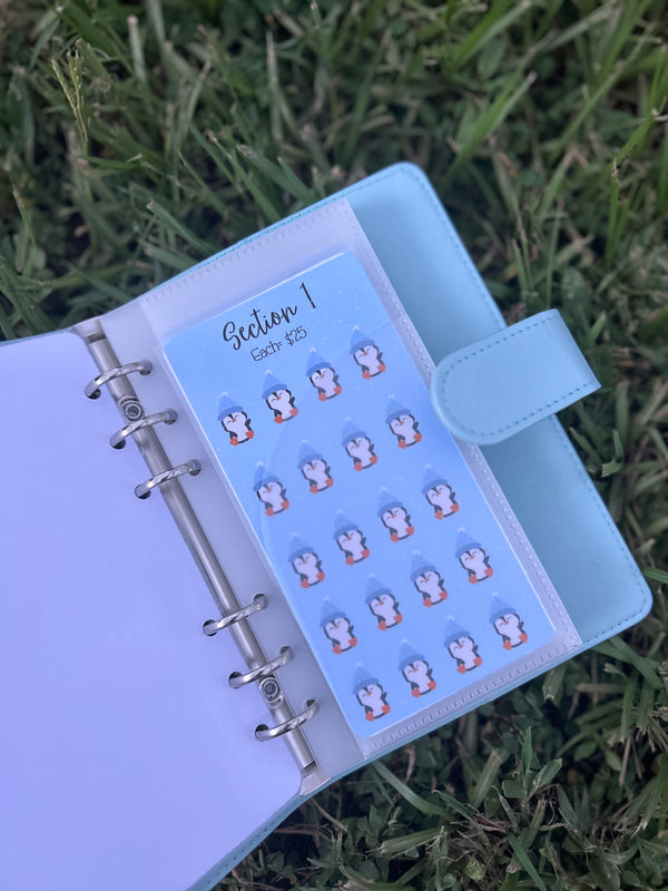 Planner with a sheet of stickers featuring cartoon characters on grass