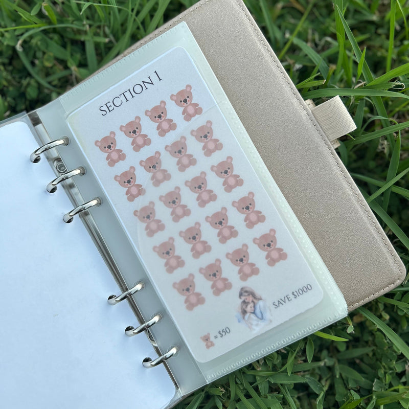 Notebook with a sheet of bear stickers on grass