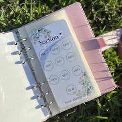 Planner with money management stickers on grass