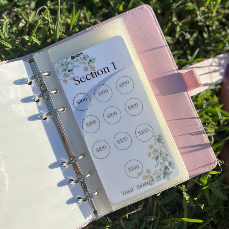 Planner with money management stickers on grass