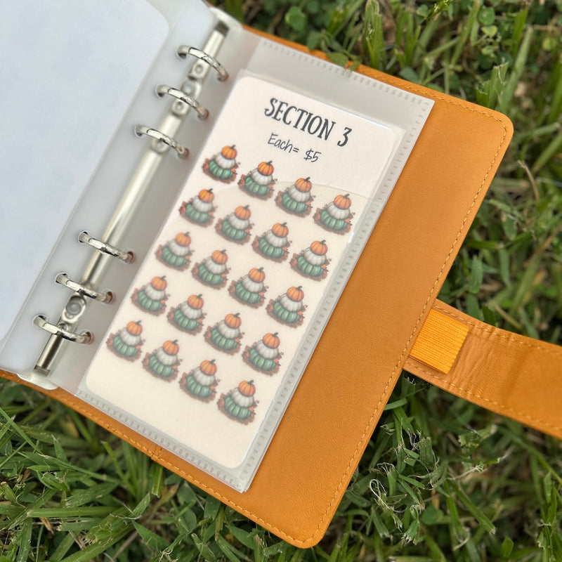 Open notebook with a sheet of stickers on grass