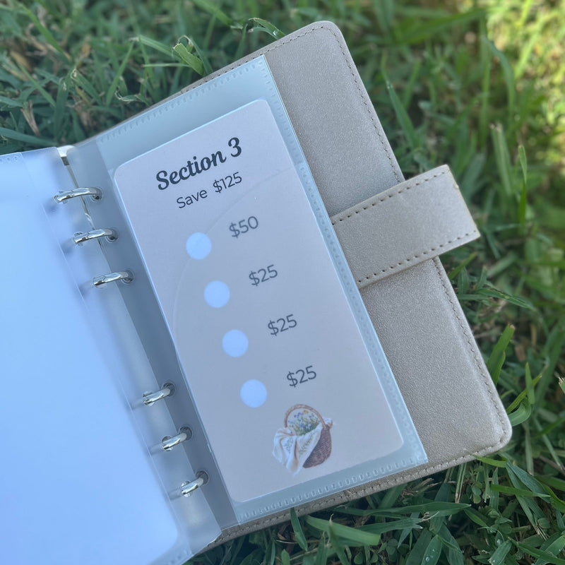 Small notebook with money tracking section on grass