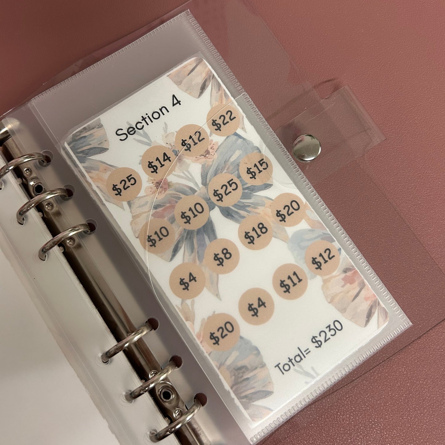 Planner with labeled tabs on a pink background