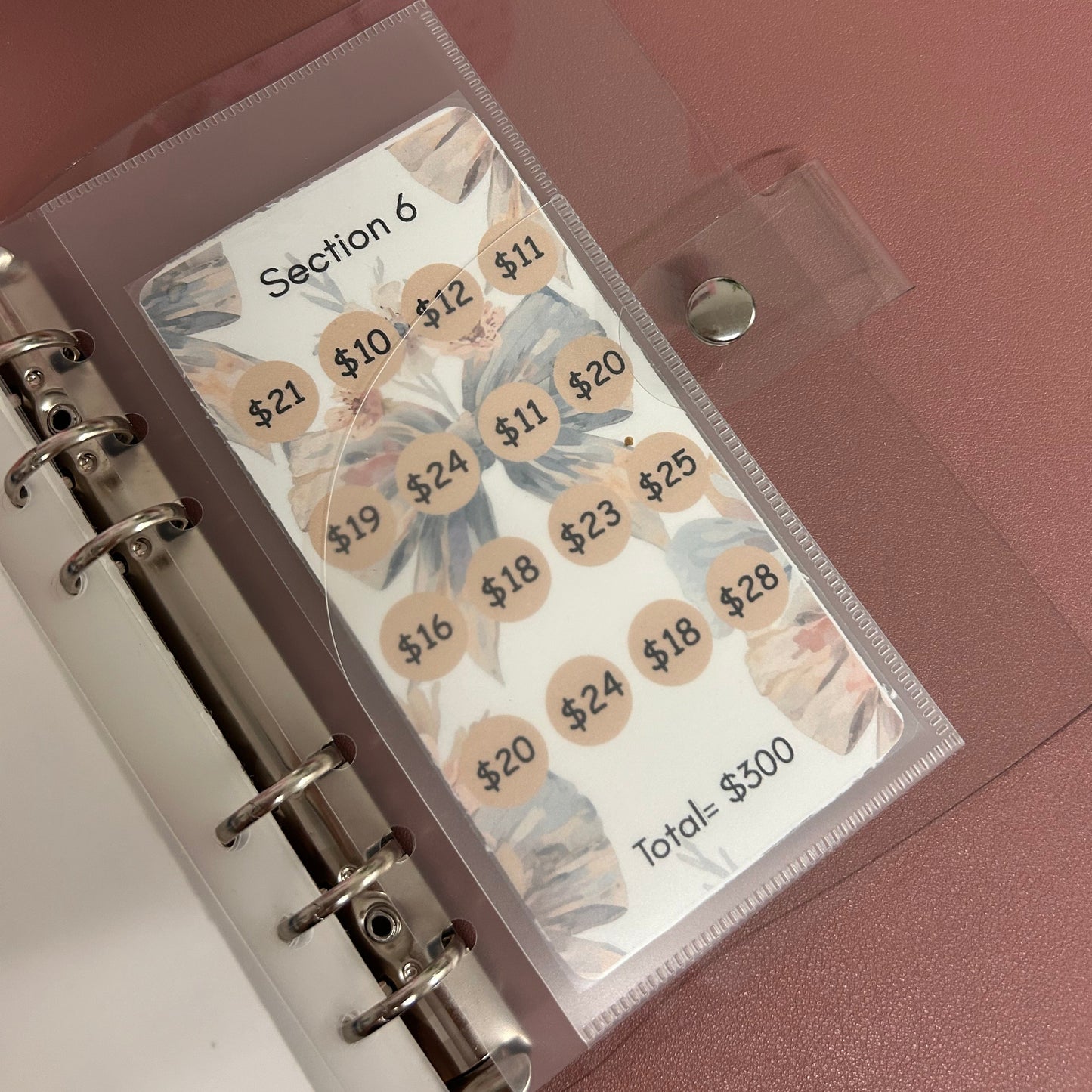 Planner with labeled tabs on a pink background