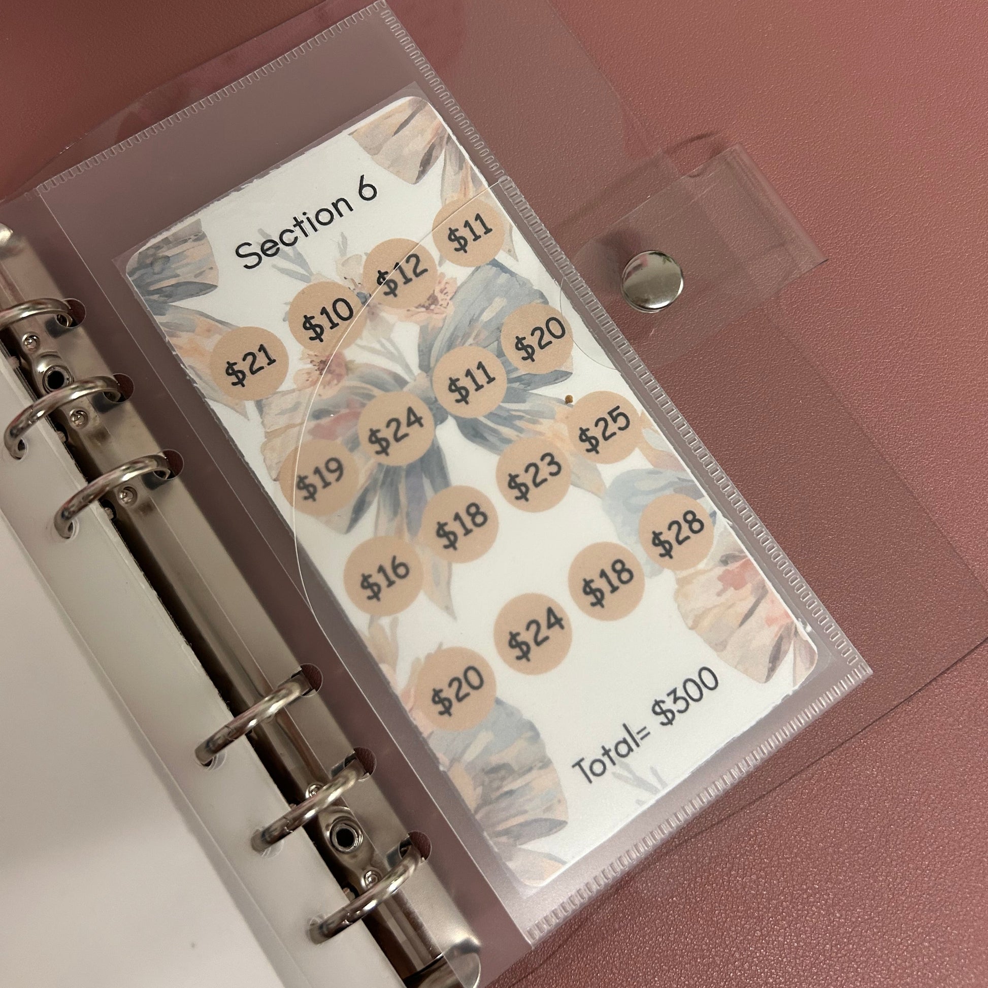 Planner with labeled tabs on a pink background