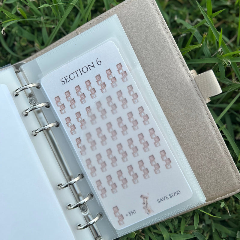 Small notebook with a sheet of stickers on grass