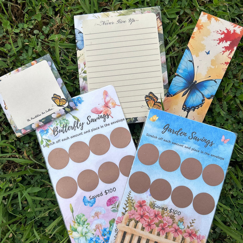 Collection of stationery items including a notepad, stickers, and a card on grass
