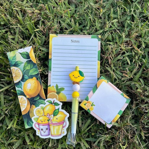 Set of stationery items with lemon theme on grass