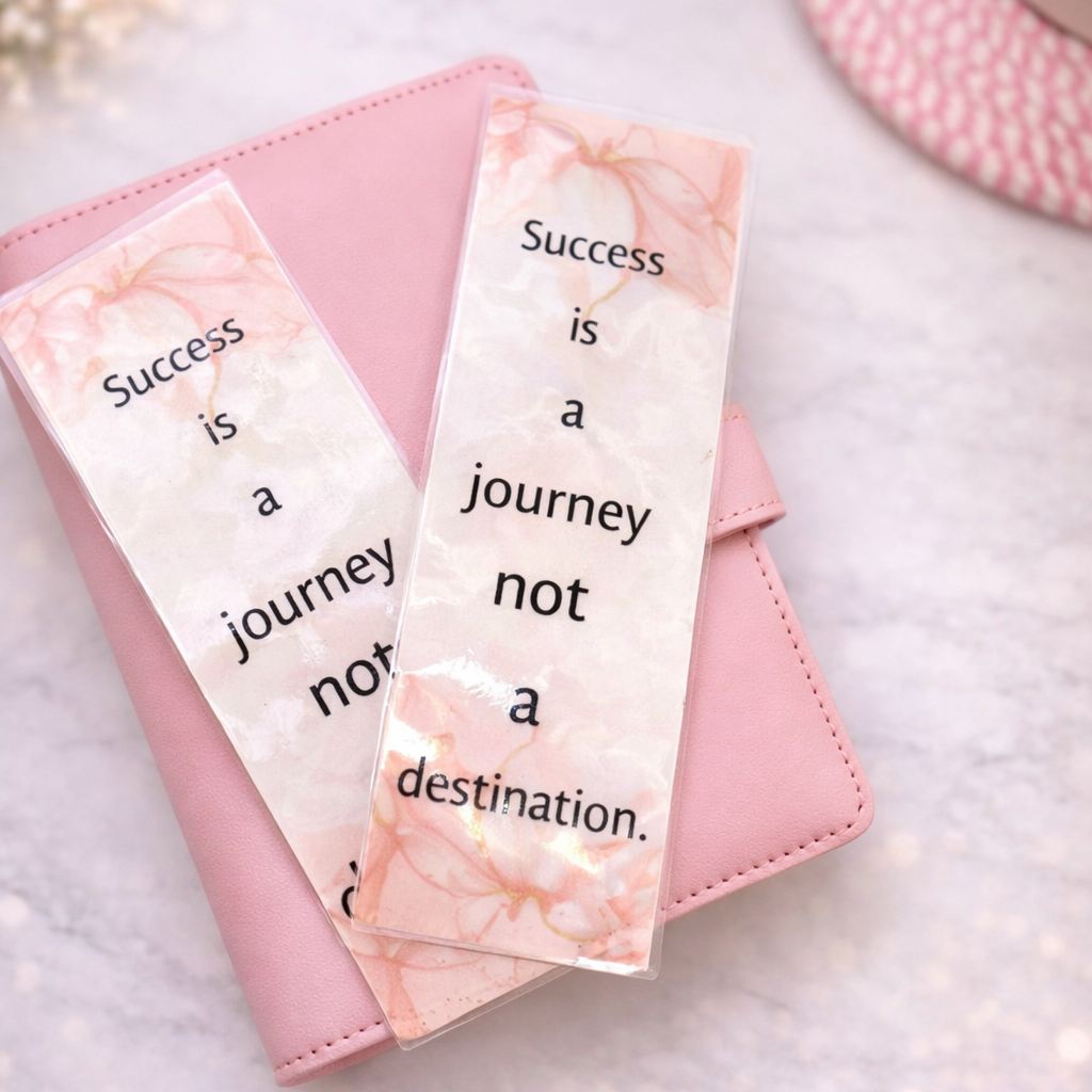 Pink notebook with marble bookmarks on a light background