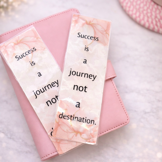 Pink notebook with marble bookmarks on a light background