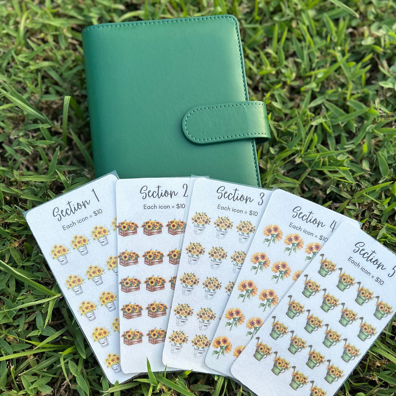 Green planner with floral stickers on grass