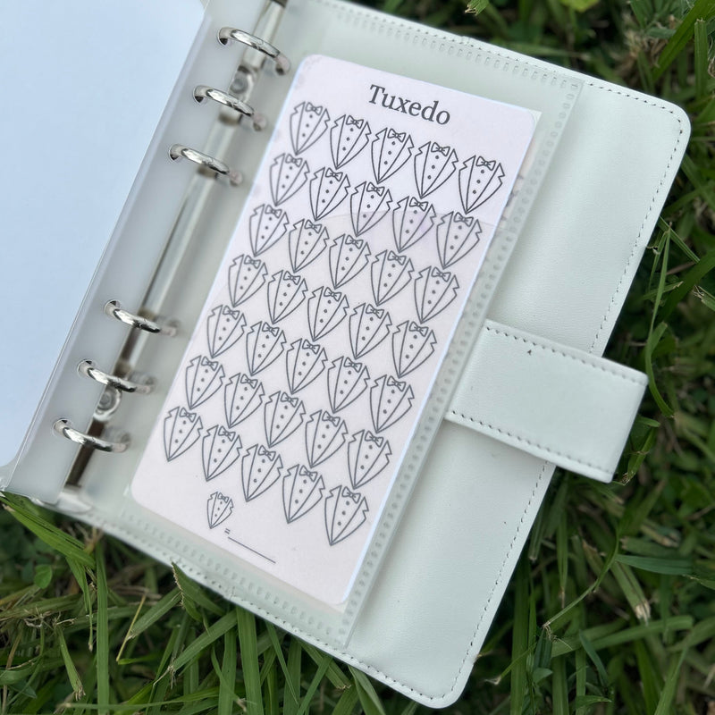 white planner with a card labeled 'Tuxedo' on grass