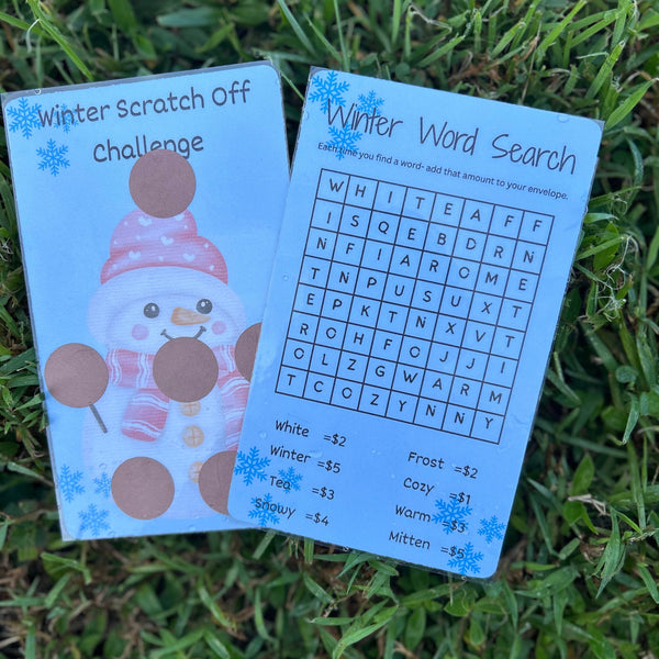 Two educational cards, one with a snowman design and the other with a word search, on grass.