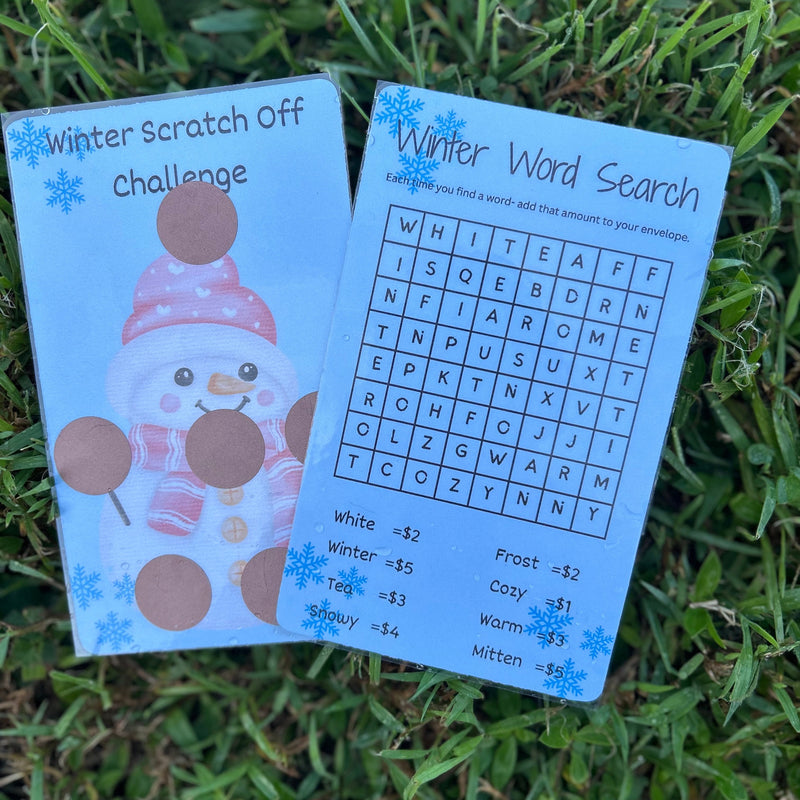 Two educational cards, one with a snowman design and the other with a word search, on grass.